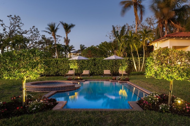 view of swimming pool featuring a yard and an in ground hot tub