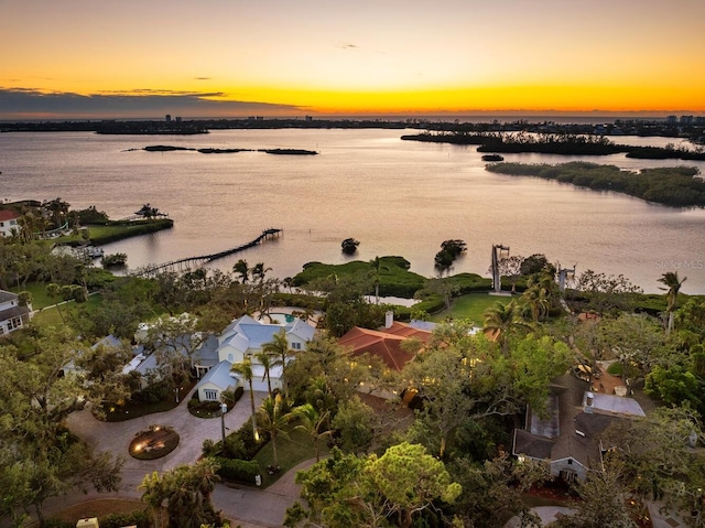 aerial view at dusk featuring a water view