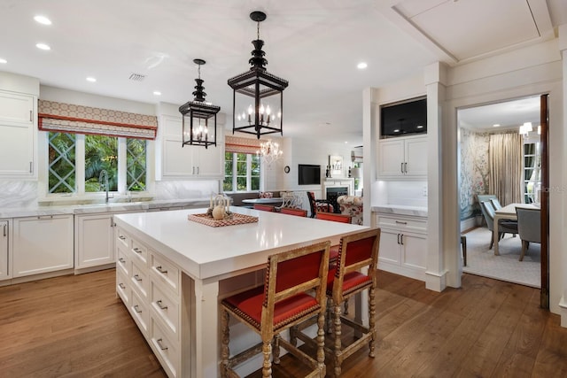 kitchen featuring dark wood-style floors, a sink, a chandelier, and light countertops