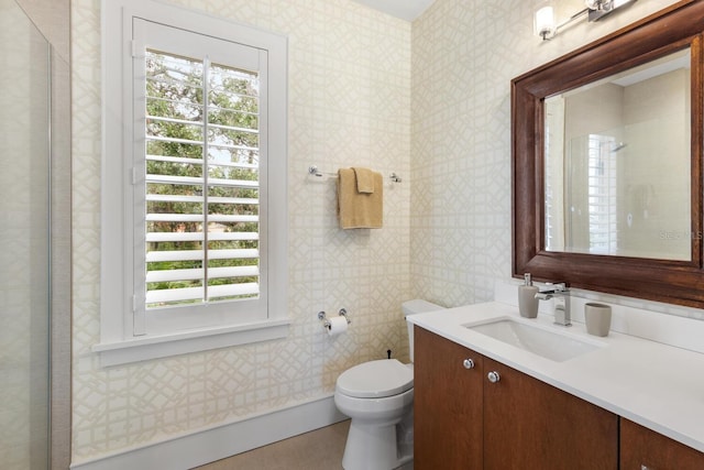 bathroom with wallpapered walls, vanity, and toilet