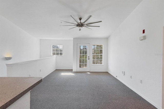 unfurnished living room featuring carpet and ceiling fan