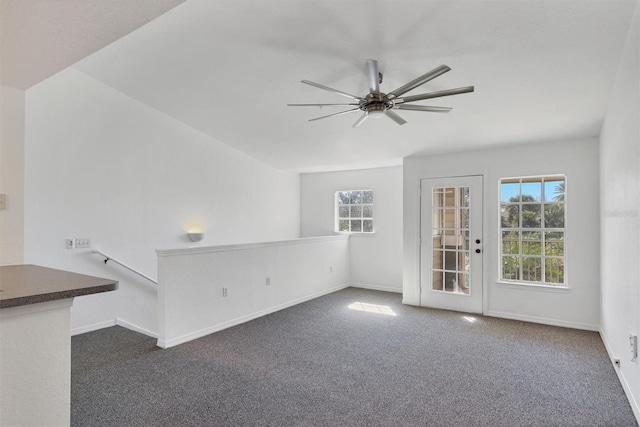 empty room featuring ceiling fan and dark carpet