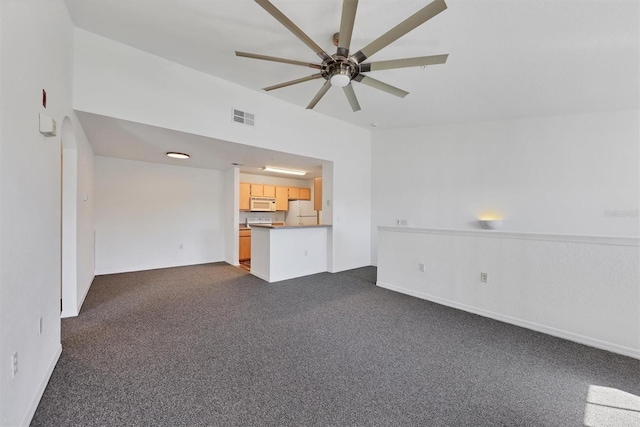 unfurnished living room featuring dark colored carpet and ceiling fan