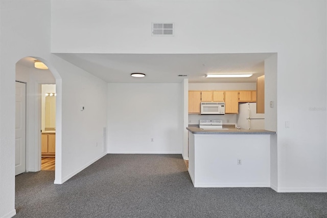 kitchen featuring dark colored carpet, light brown cabinets, and white appliances