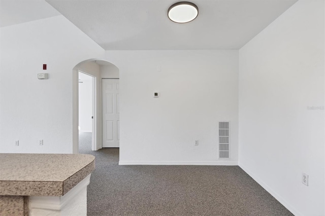 spare room with dark colored carpet