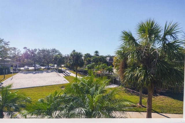 view of home's community with volleyball court and a lawn