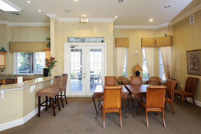 dining room featuring carpet flooring, french doors, plenty of natural light, and ornamental molding