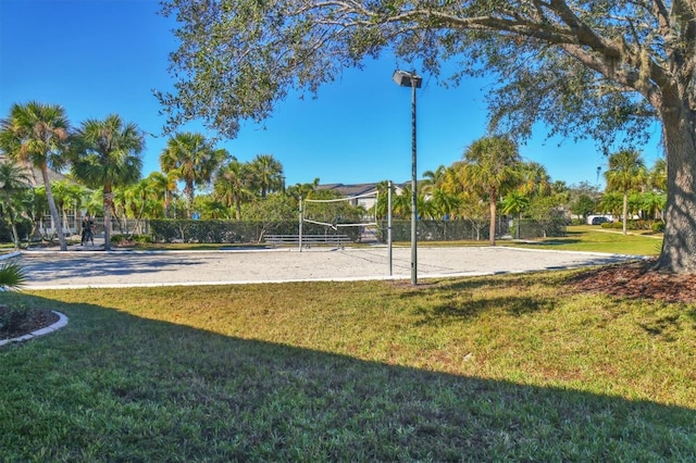 view of community with volleyball court and a lawn