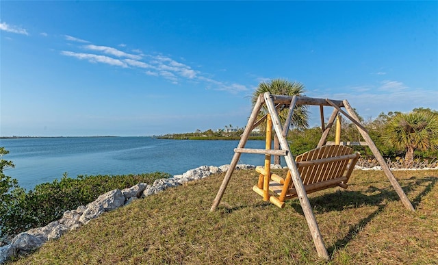 view of jungle gym featuring a water view and a yard