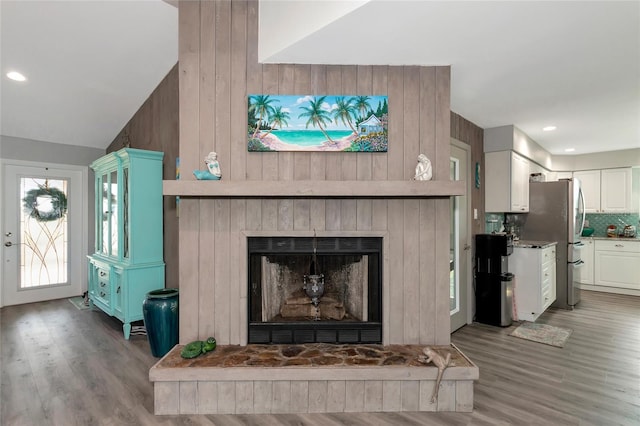 living room featuring lofted ceiling and wood-type flooring