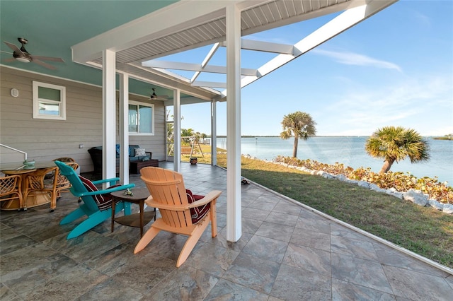 view of patio with ceiling fan and a water view