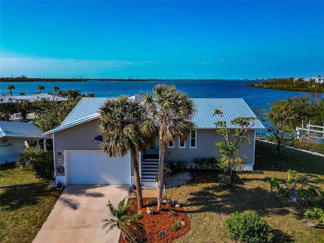 view of front of home featuring a front yard, a garage, and a water view