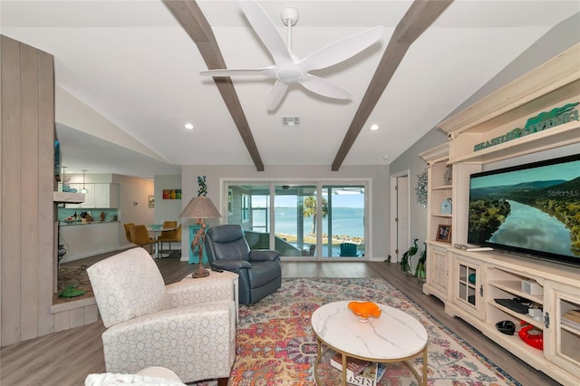 living room featuring ceiling fan, vaulted ceiling with beams, and light wood-type flooring