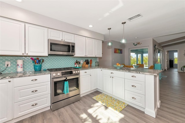 kitchen featuring decorative light fixtures, appliances with stainless steel finishes, kitchen peninsula, light stone countertops, and white cabinets