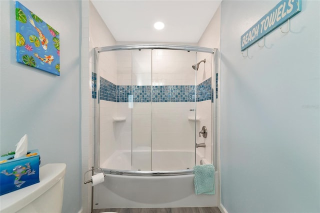 bathroom with enclosed tub / shower combo and toilet