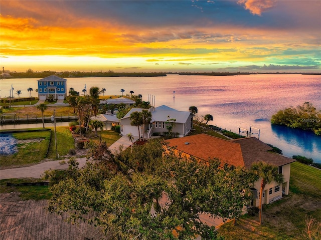 aerial view at dusk featuring a water view