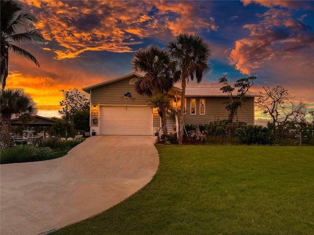 view of front of home featuring a garage and a lawn