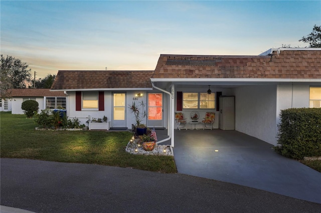 ranch-style home with a carport and a lawn