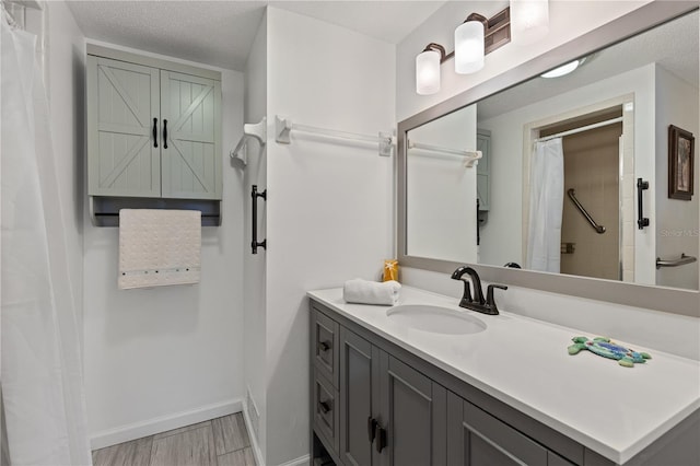 bathroom with a textured ceiling, vanity, and a shower with curtain