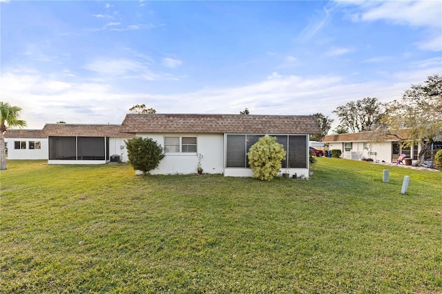 back of property featuring a lawn, a sunroom, and cooling unit