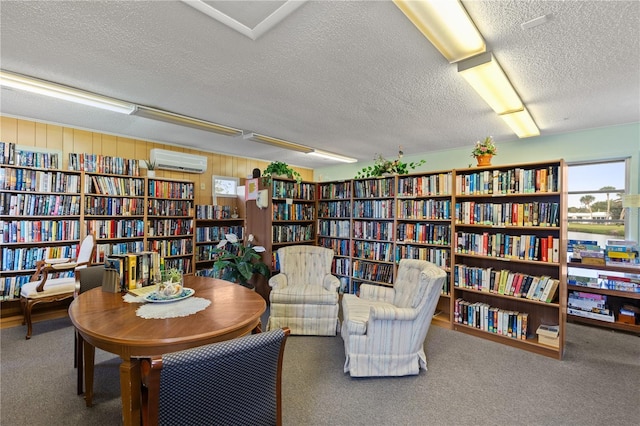 living area with carpet flooring, wood walls, a textured ceiling, and a wall unit AC