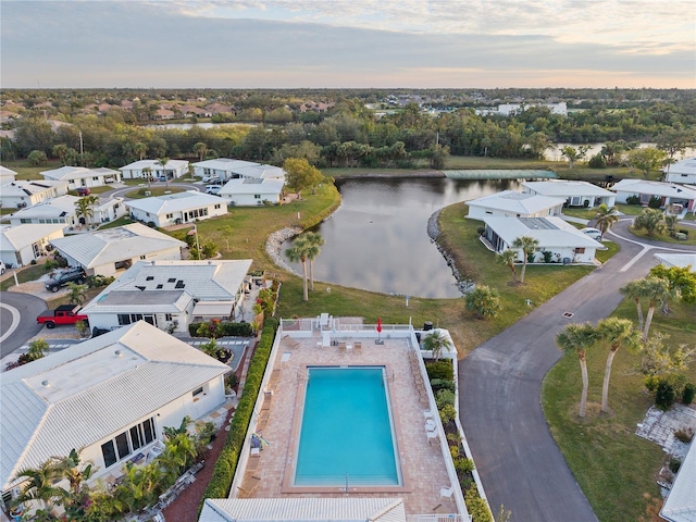 aerial view at dusk featuring a water view