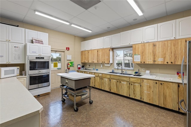 kitchen featuring a paneled ceiling, a wealth of natural light, and appliances with stainless steel finishes