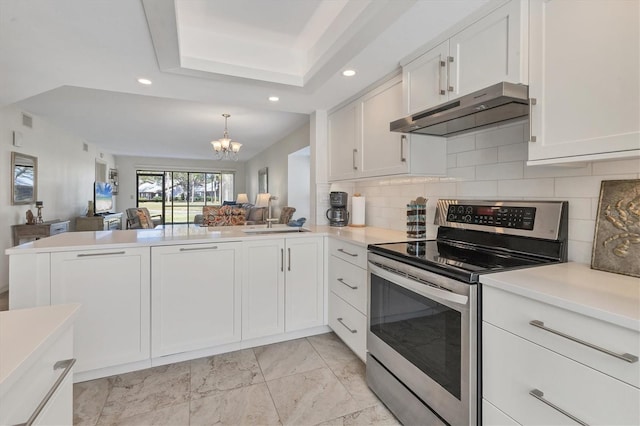 kitchen featuring backsplash, stainless steel range with electric cooktop, an inviting chandelier, white cabinets, and kitchen peninsula