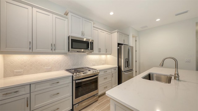 12649 Palatka Dr, Venice, FL 34293 - kitchen with stainless steel appliances, white cabinets, sink, and light hardwood / wood-style floors