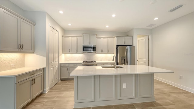 12649 Palatka Dr, Venice, FL 34293 - kitchen featuring stainless steel appliances, a kitchen island with sink, decorative backsplash, and sink