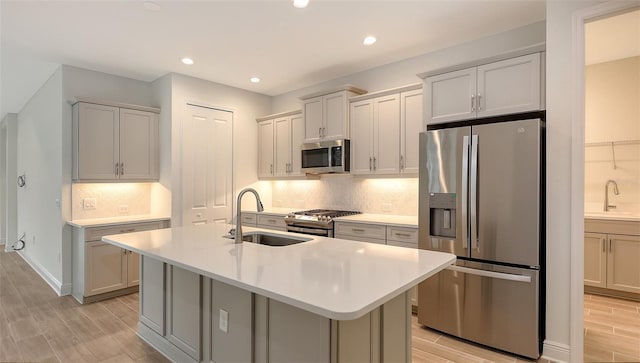 12649 Palatka Dr, Venice, FL 34293 - kitchen featuring decorative backsplash, appliances with stainless steel finishes, a kitchen island with sink, and sink
