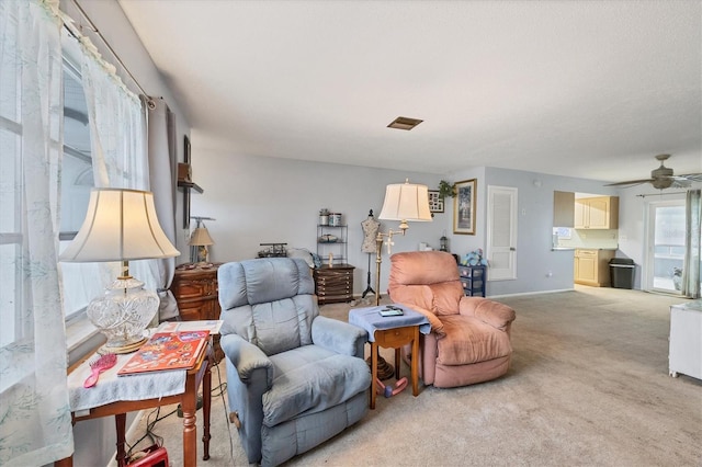 carpeted living room with ceiling fan