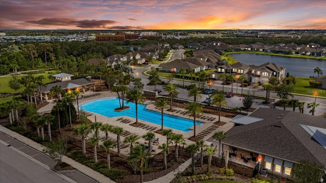 pool at dusk featuring a water view