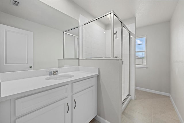 bathroom featuring tile patterned flooring, vanity, and an enclosed shower