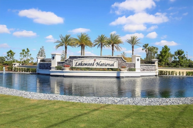 community sign with a yard and a water view