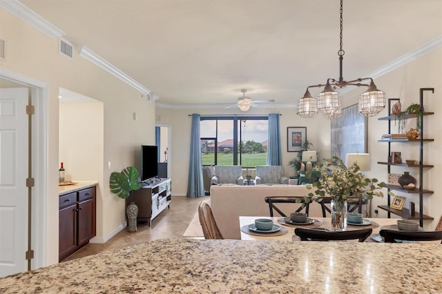 tiled dining area featuring crown molding and ceiling fan with notable chandelier