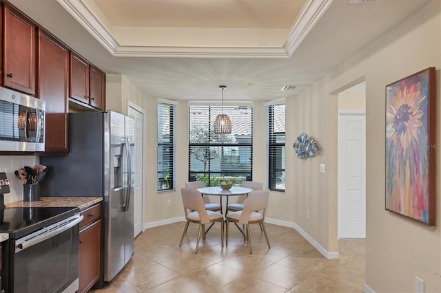 kitchen with a raised ceiling, ornamental molding, hanging light fixtures, and appliances with stainless steel finishes