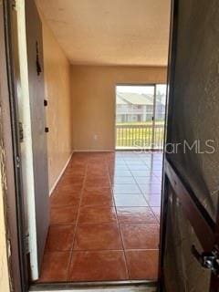 hallway with dark tile patterned flooring