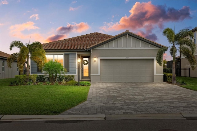 view of front of home with a lawn and a garage