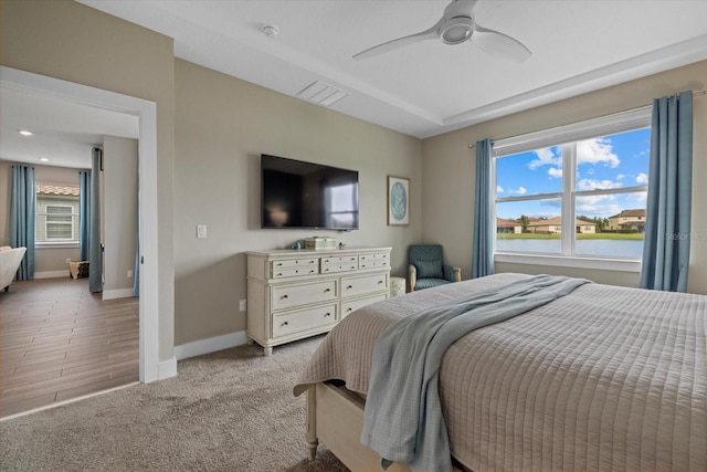 bedroom featuring multiple windows, ceiling fan, and light carpet