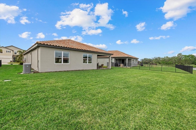 rear view of property with a yard and central air condition unit