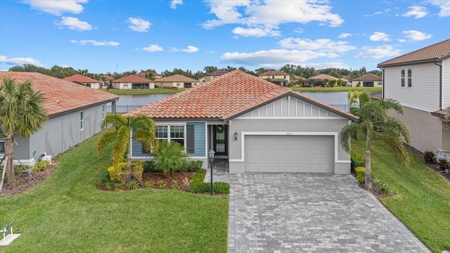 view of front facade featuring a front yard, a water view, and a garage