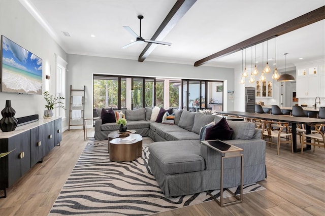 living room featuring beamed ceiling, ceiling fan, light hardwood / wood-style floors, and crown molding