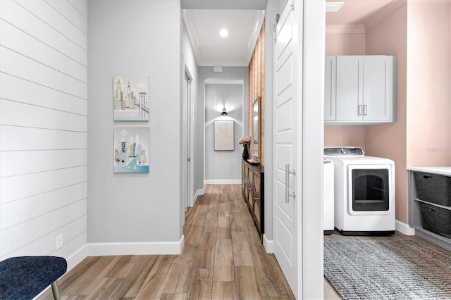 clothes washing area featuring cabinets and light hardwood / wood-style flooring