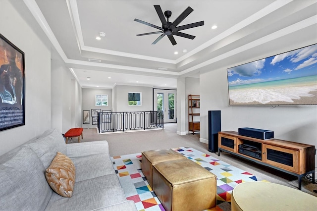 living room featuring a tray ceiling, ceiling fan, and ornamental molding