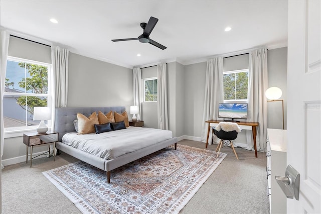 carpeted bedroom with multiple windows, ceiling fan, and ornamental molding