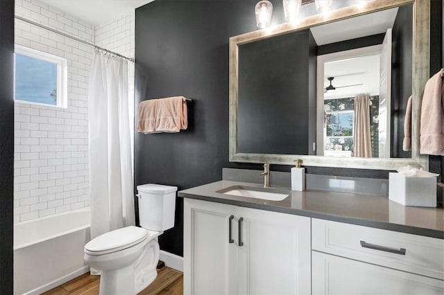 full bathroom with vanity, hardwood / wood-style flooring, ceiling fan, toilet, and shower / bathtub combination with curtain