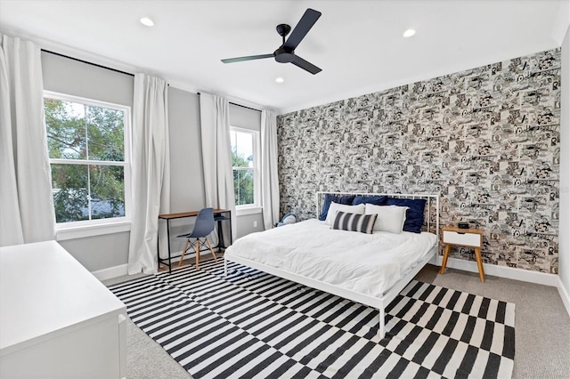 carpeted bedroom featuring multiple windows and ceiling fan