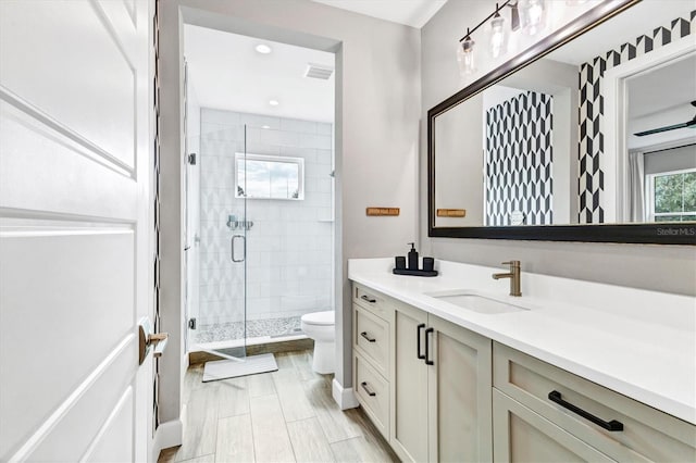 bathroom featuring vanity, toilet, and an enclosed shower