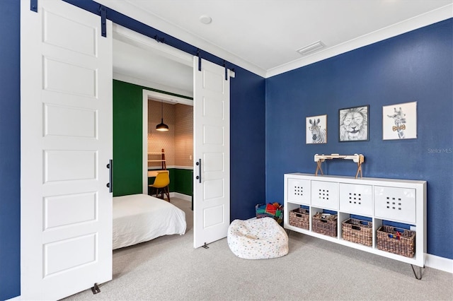 carpeted bedroom with a barn door and ornamental molding